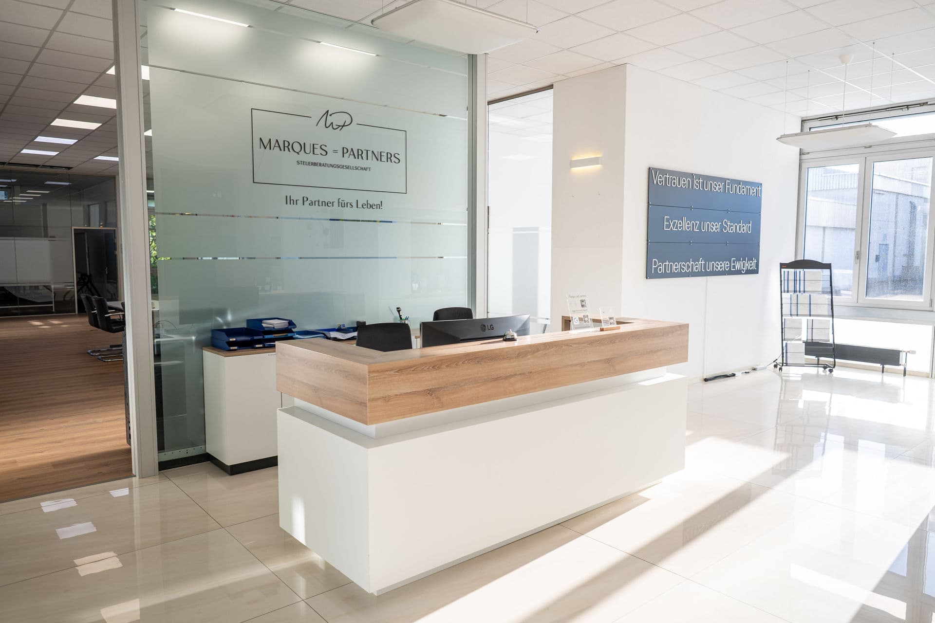 Empfang der Kanzlei mit dem Schriftzug „Marques = Partners, Steuerberatungsgesellschaft“ auf der Glaswand